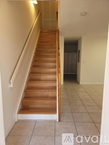 A wooden staircase with a white railing.