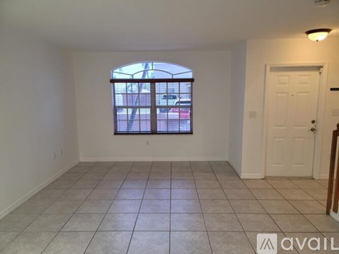 A room with a large window and tiled floor is available for rent.