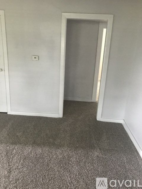 A room with a carpeted floor and a white door.