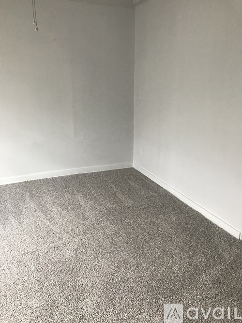 A room with grey carpet and white walls.