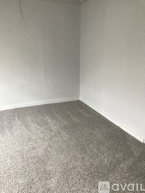 A room with grey carpet and white walls.