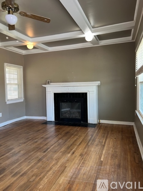 A room with a fireplace and wood flooring.