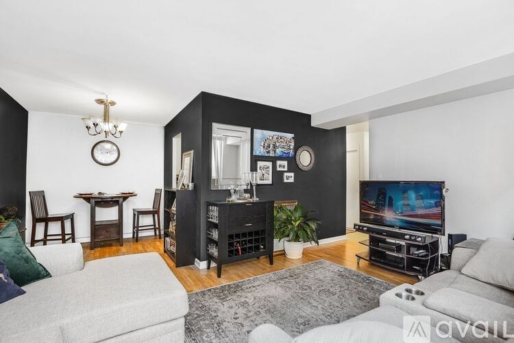 A living room with a grey sofa, a black cabinet, and a television.