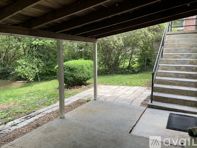 A wooden covered walkway leads to a set of outdoor stairs.