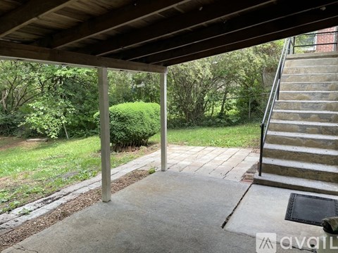 A wooden covered walkway leads to a set of outdoor stairs.
