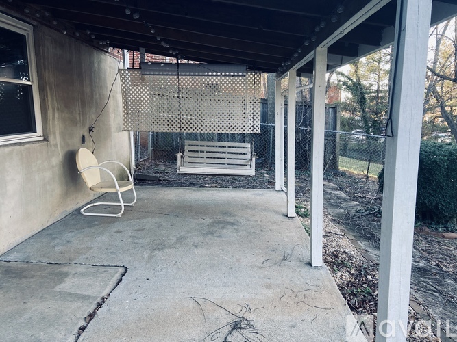 A patio with a white chair and a white bench.