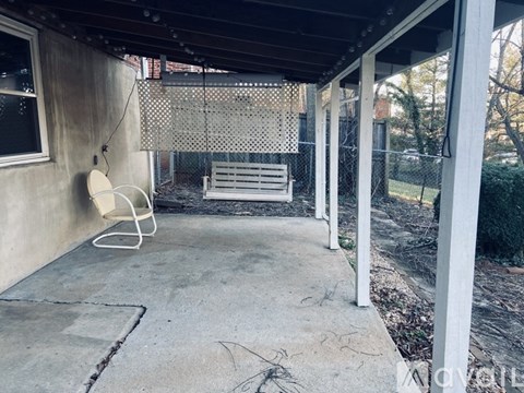 A patio with a white chair and a white bench.