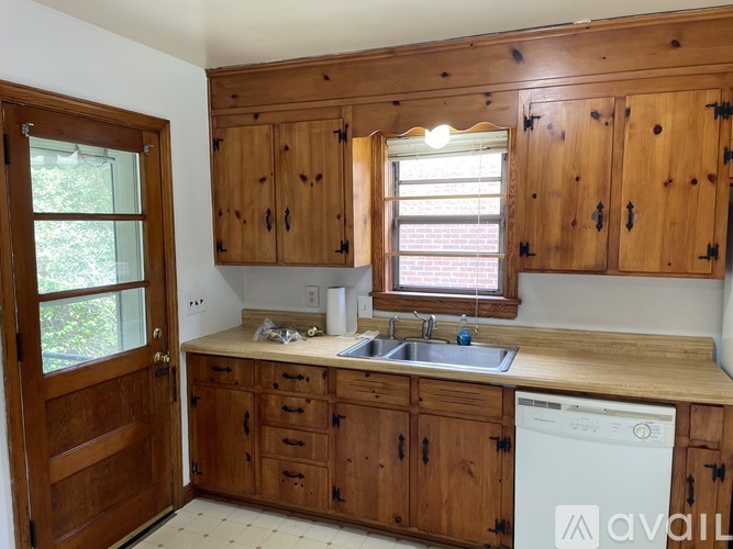 A kitchen with wooden cabinets and a white dishwasher.