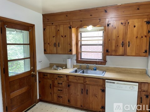 A kitchen with wooden cabinets and a white dishwasher.