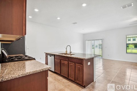 A kitchen with brown cabinets and granite countertops.