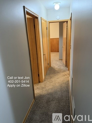 A hallway with a phone number and an application process for a Zillow listing.