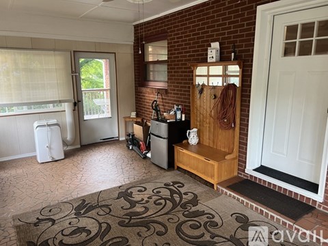 A kitchen area with a refrigerator, a sink, and a window with blinds.