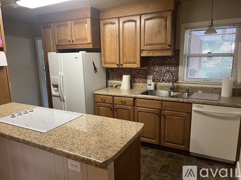 A kitchen with a white refrigerator and brown cabinets.