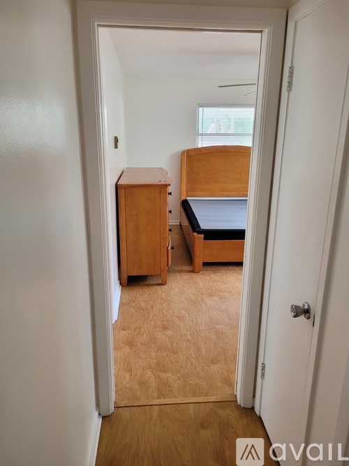 A bedroom with a bed, dresser and cupboard.