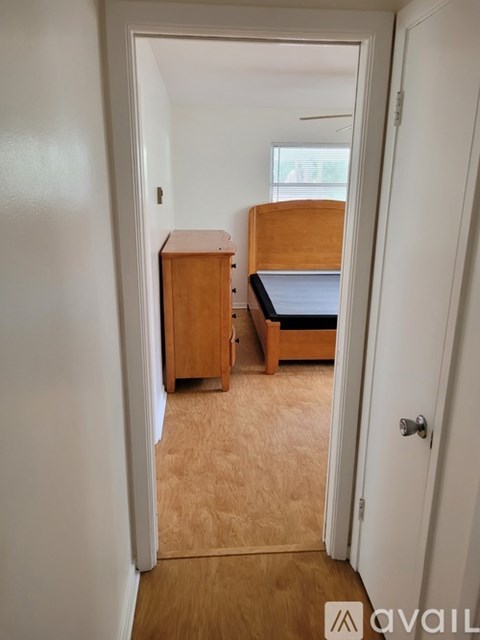 A bedroom with a bed, dresser and cupboard.