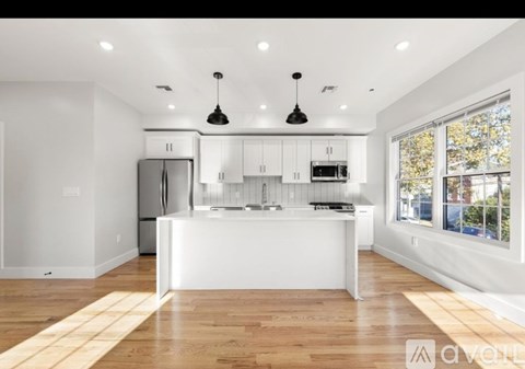 A modern kitchen with white cabinets and a central island.
