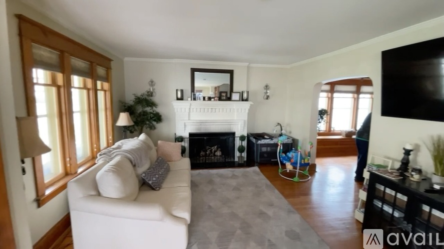 A living room with a white couch and a fireplace.