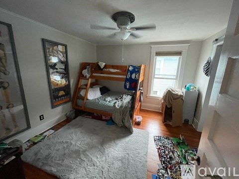 A bedroom with a bunk bed and a ceiling fan.