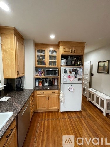 A kitchen with wooden cabinets and a white fridge.