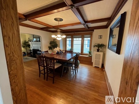 A dining room with a wooden table and chairs.