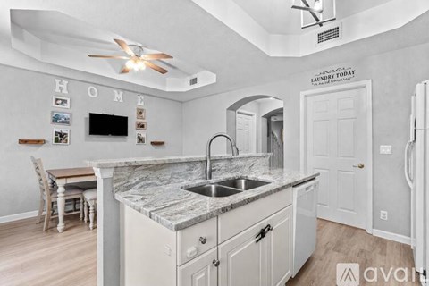 A kitchen with a marble countertop and a ceiling fan.