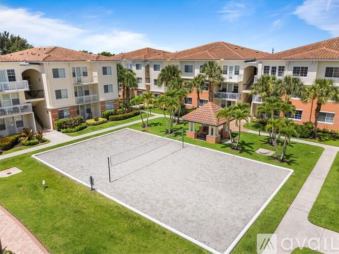 A tennis court is surrounded by apartment buildings.