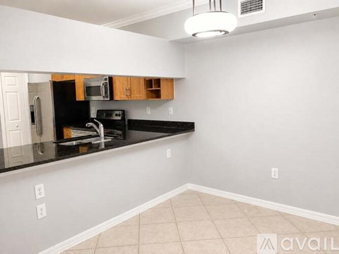A kitchen with black countertops and white walls.