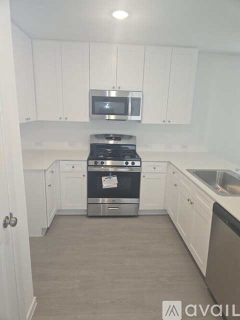 A kitchen with white cabinets and a stainless steel oven.