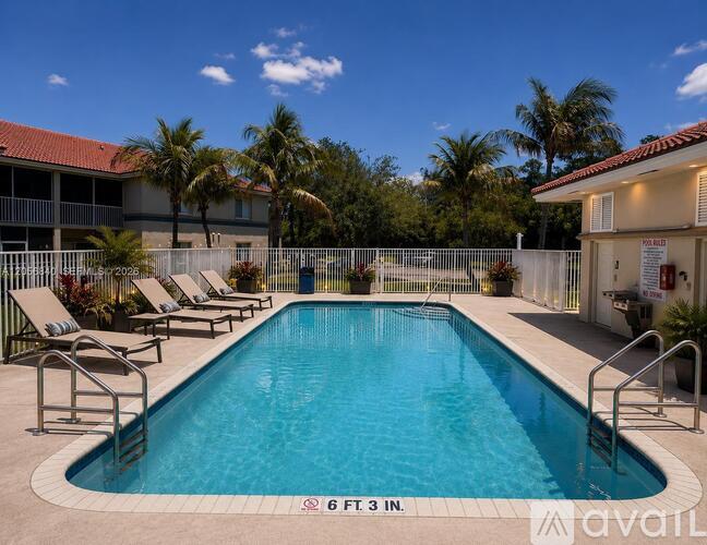 A pool with a depth of 6 feet 3 inches is surrounded by lounge chairs.