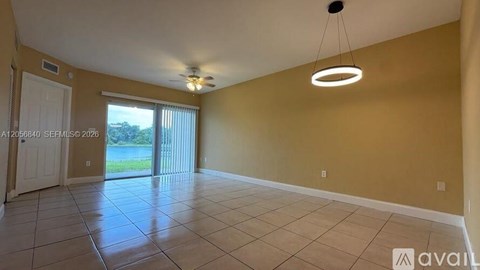 A living room with a sliding glass door leading to a backyard.