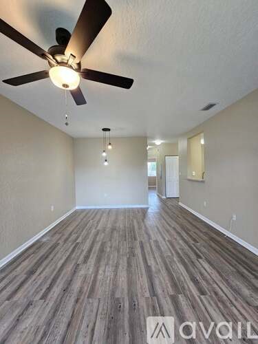 A room with wooden flooring and a ceiling fan.