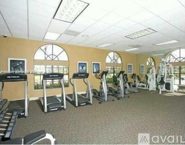 A gym with treadmills, elliptical machines, and other exercise equipment.