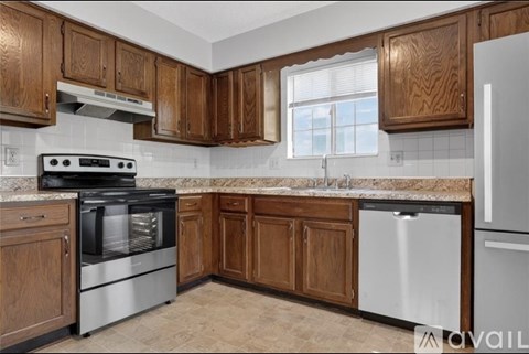 A kitchen with wooden cabinets and a stainless steel oven.