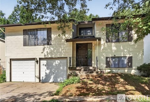 A two-story house with a garage on the first floor and a balcony on the second floor.