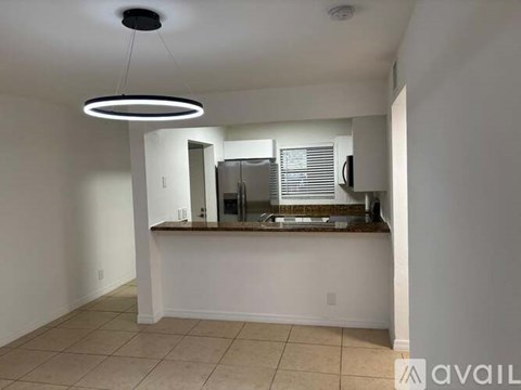 A kitchen area with a counter and a fridge.