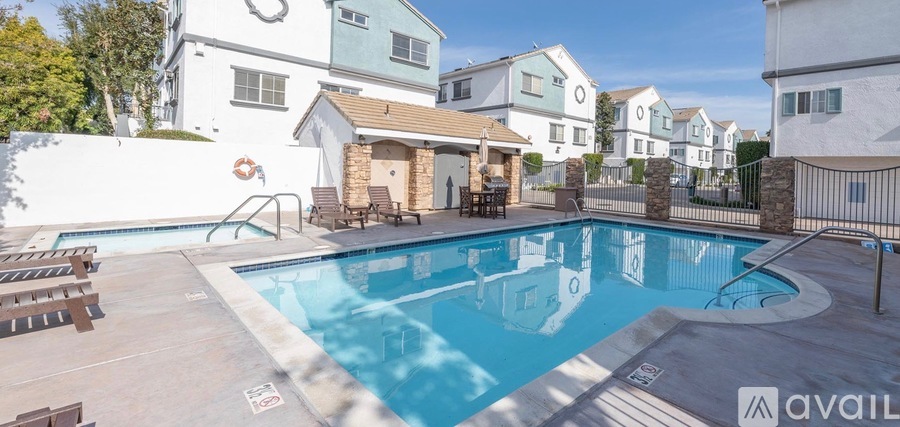 A swimming pool surrounded by a fence and a building in the background.