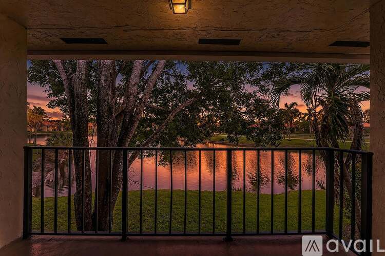 A balcony overlooks a body of water with trees in the background.