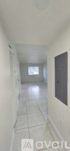 A long hallway with a door on the right side.