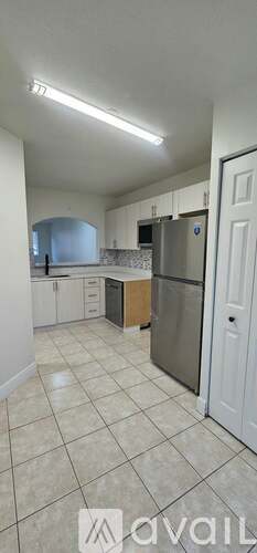 A kitchen with white cabinets and a tiled floor.