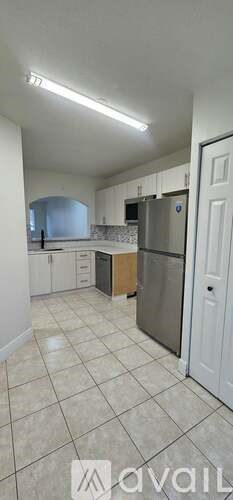 A kitchen with white cabinets and a tiled floor.