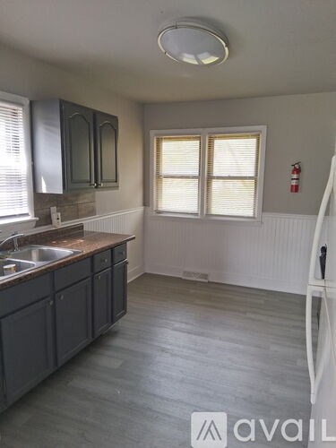 A kitchen with dark wood cabinets and a white sink.