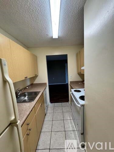 A kitchen with a sink, dishwasher, and refrigerator.