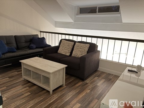 A living room with a brown couch and a wooden coffee table.