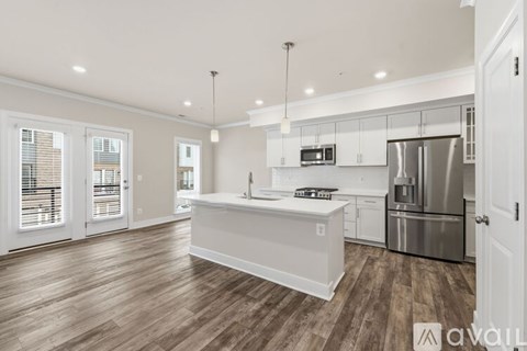 A kitchen with white cabinets and a wooden floor.