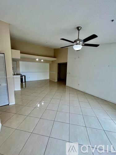 A spacious room with a ceiling fan and tiled flooring.