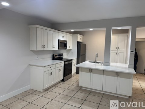 A kitchen with white cabinets and appliances.