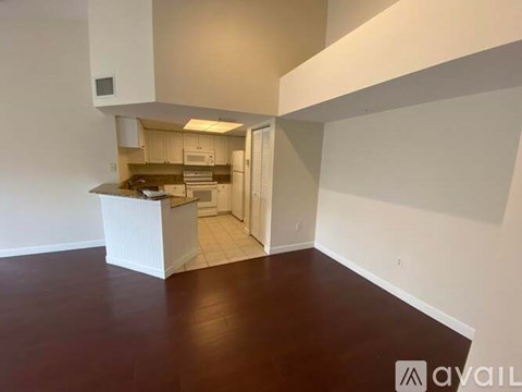 A kitchen area with a counter and cabinets is visible from the living room.