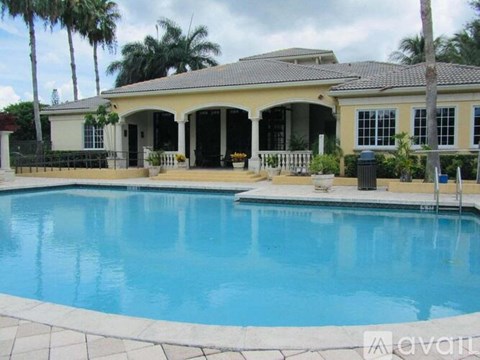 A house with a pool in front of it.