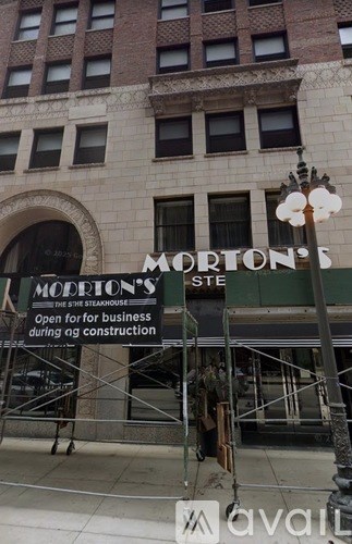 A sign for Morton's Steakhouse is displayed in front of a building under construction.