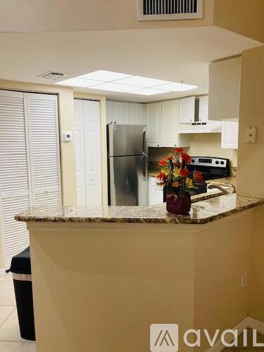 A kitchen with a granite countertop and a refrigerator.